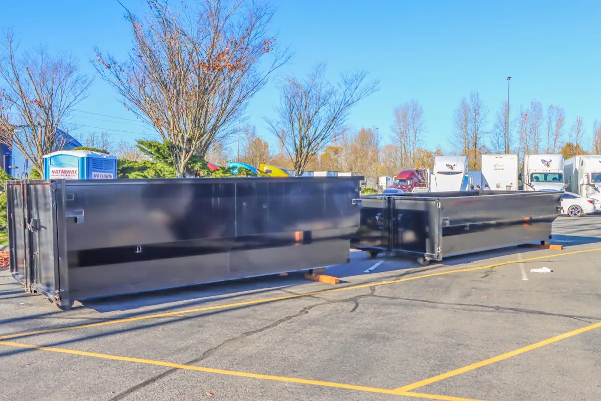 Professional dumpster rental service with roll-off container on residential driveway in Iola